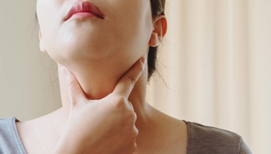 Woman holding neck testing her thyroid gland