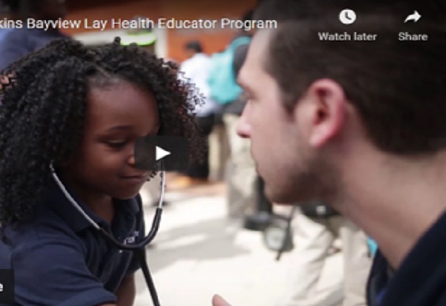 child wearing a stethoscope next to a medical professional