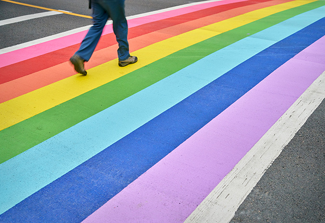 a street's crosswalk painted with a rainbow