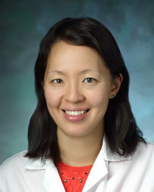 Dr. Eva Tseng smiles for a professional photo while wearing her white coat.