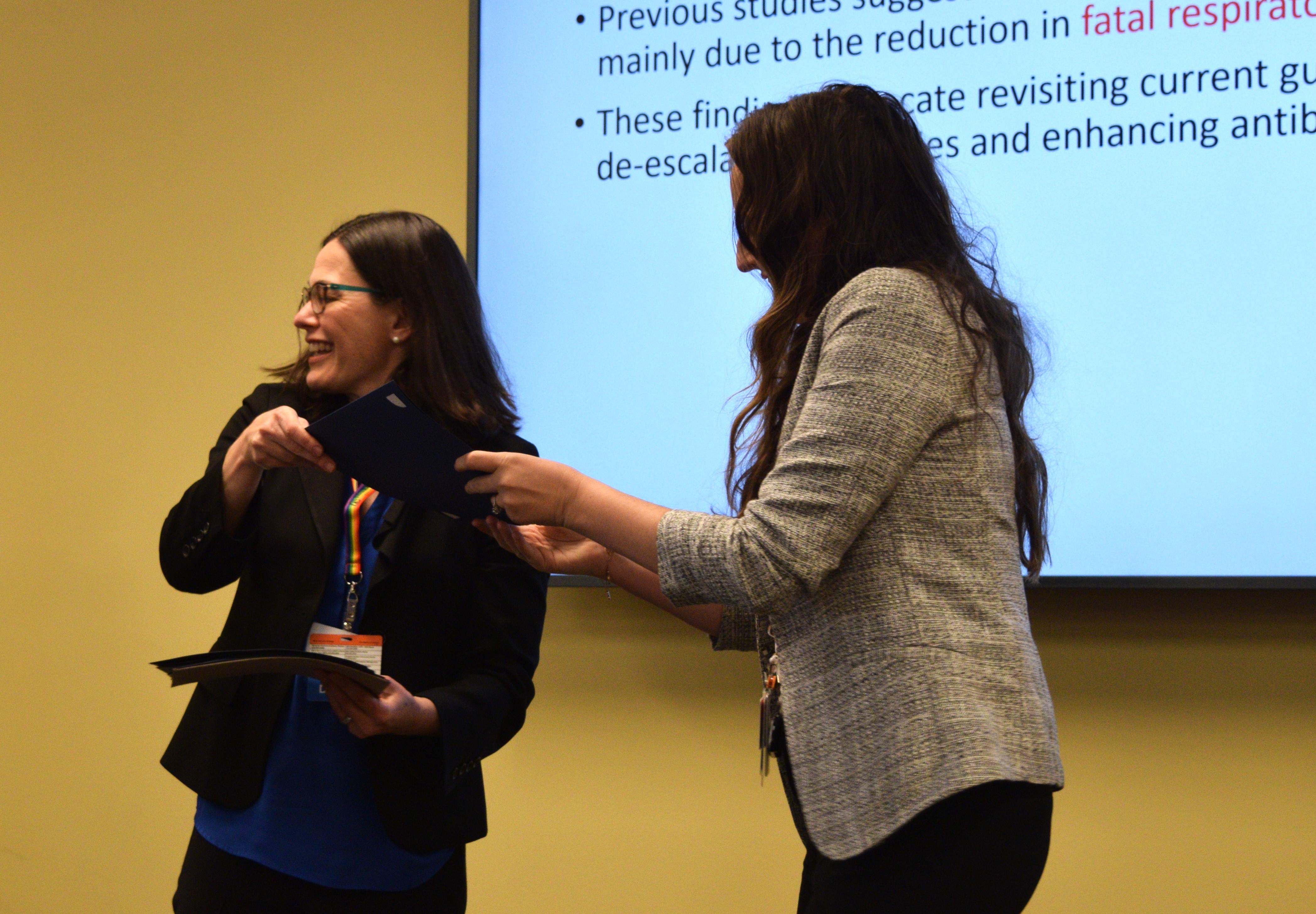 Wendy Bennett (left) hands an award to Housestaff winner Nicole Robertson.