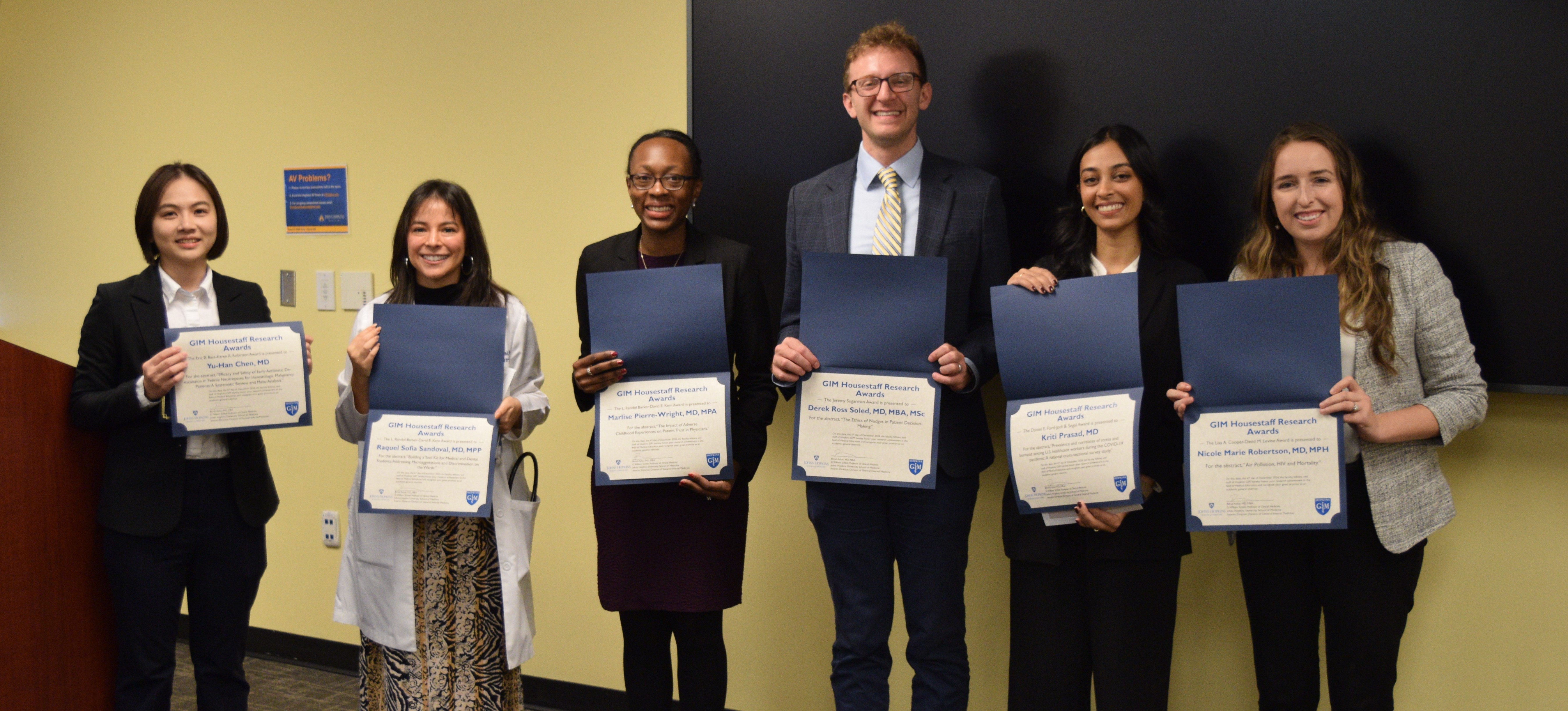 2024 Housestaff Award winners smile for a group photo holding their certificates. 
