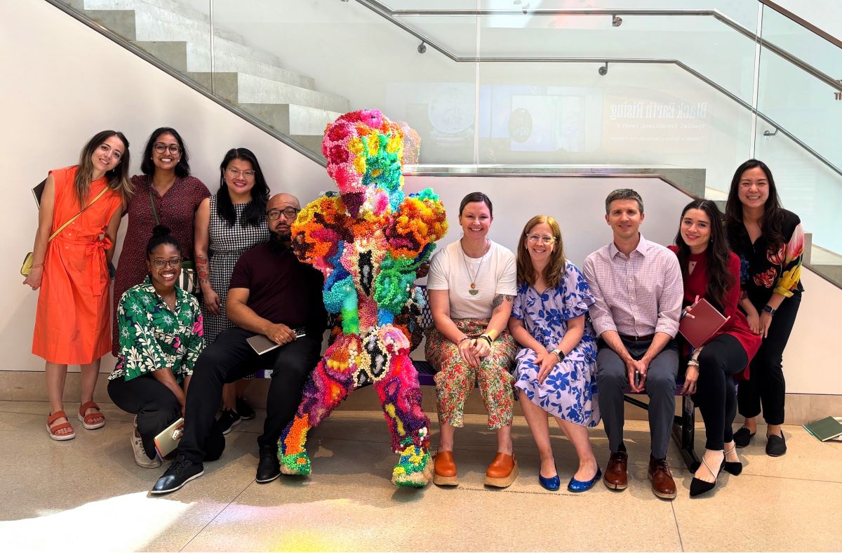 group of doctors sitting with a colorful sculpture at an art museum