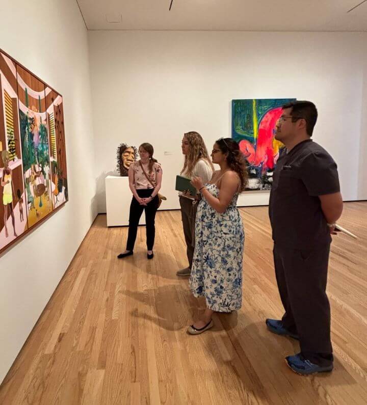 group of men and women looking at a painting