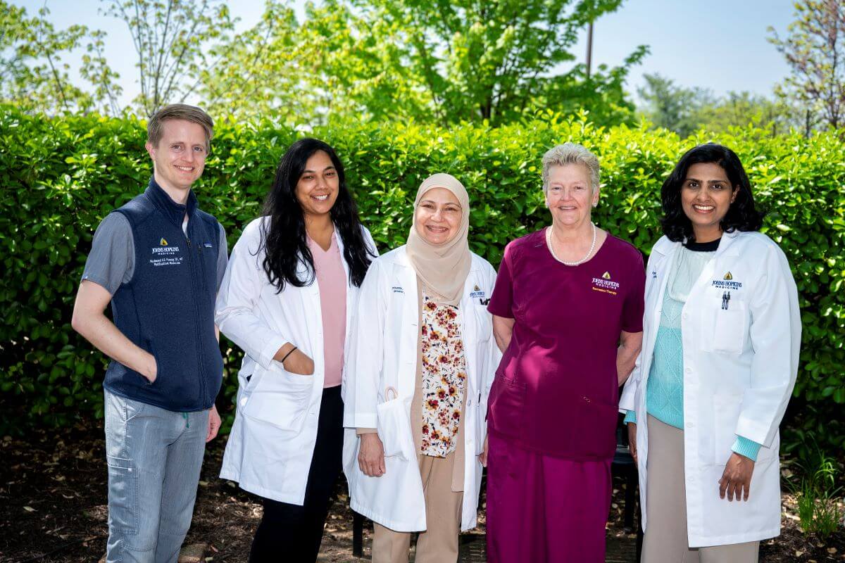 group of one male and four female doctors and physical therapists