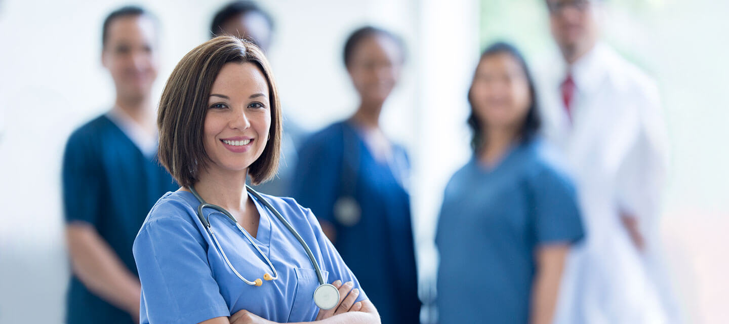 fellow smiles with other doctors behind her