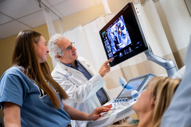 Two physicians look at a balloon for fetal therapy treatment.