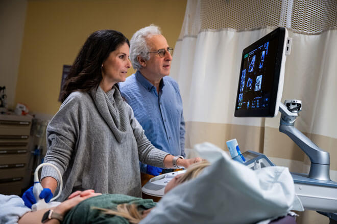 Dr. Michelle Kush and Dr. Ahmet Baschat looking over an ultrasound