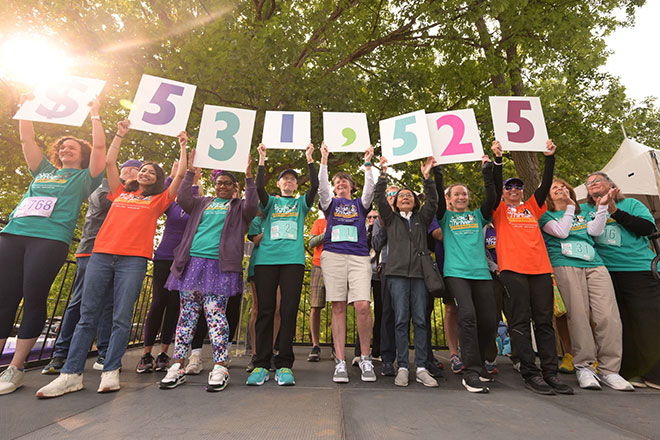 Stride and Thrive participants hold up the amount of numbers representing dollars raised from the 2025 event