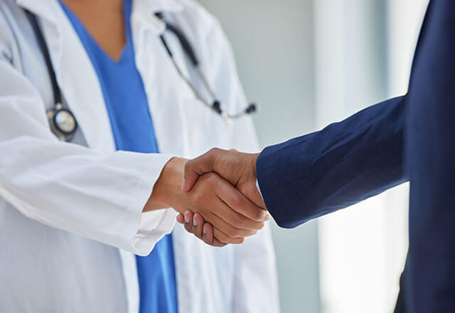 doctor and person in business suit shake hands