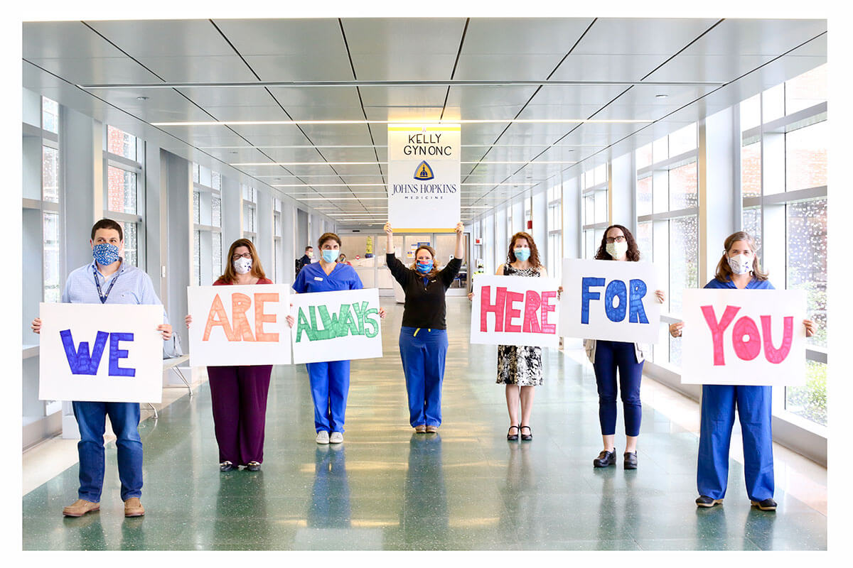 Johns Hopkins gynecology care providers holding signs that read "we are here for you".