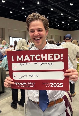 Resident holding acceptance poster.