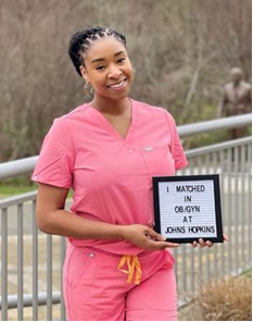 Kedeja Adams holds sign that reads I matched in OB/GYN at Hopkins