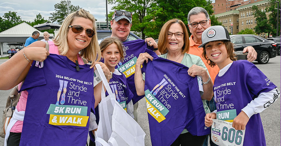 racers hold up stride and thrive tee shirts