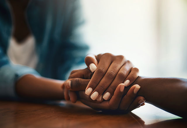 two women hold hands