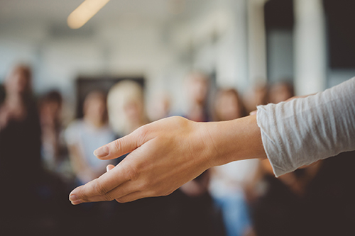 woman holding out hand during conference