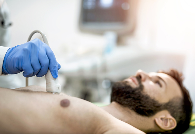 Doctor performing ultrasound on male patient's chest