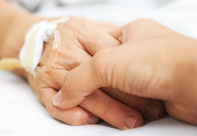 a patient holding hands with a loved one