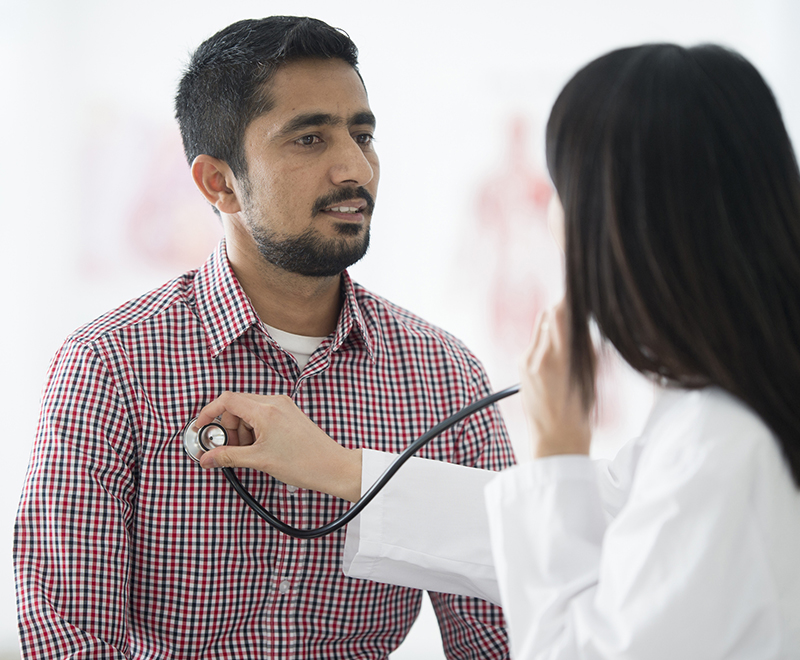 doctor listening to male patient's chest
