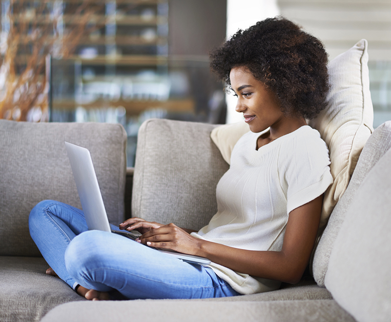 woman using laptop sitting on couch