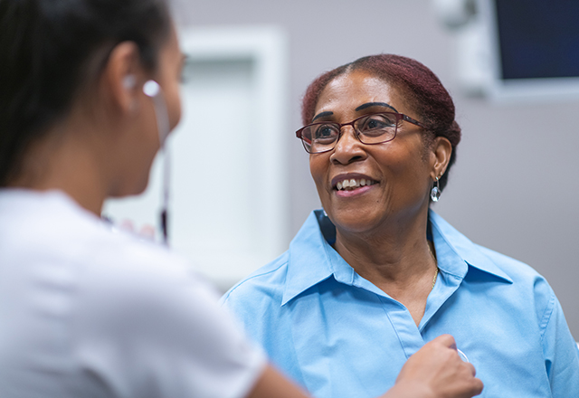 mature woman looking at nurse with stethoscope