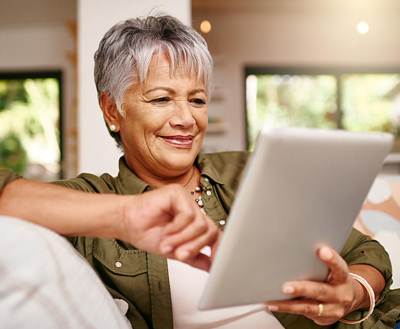 Mature woman using tablet on couch