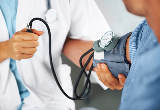 a doctor takes a man's blood pressure