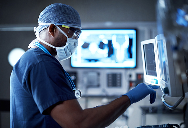 surgeon in operating room looking at machine screen