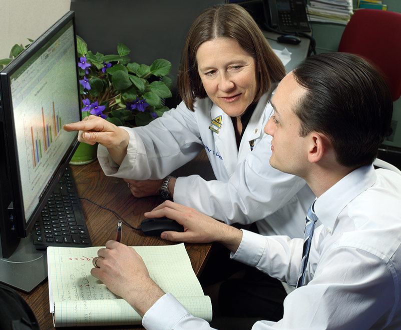 cardiac surgery research - Dr. Lawton pointing to bar graph on computer with lab researcher