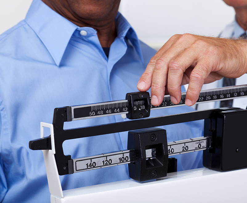 doctor checking weight of patient