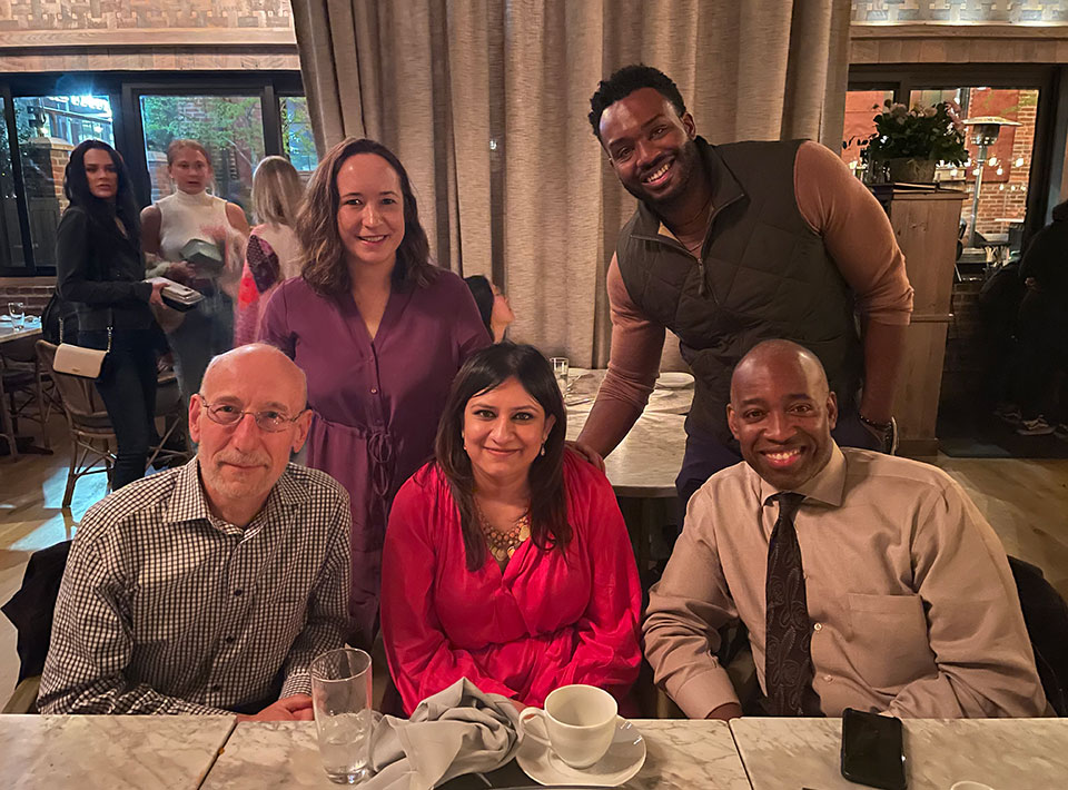 fellows posing at a restaurant with a few of their mentors