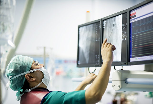 surgeon looking at screen in OR - cardiology fellowship program
