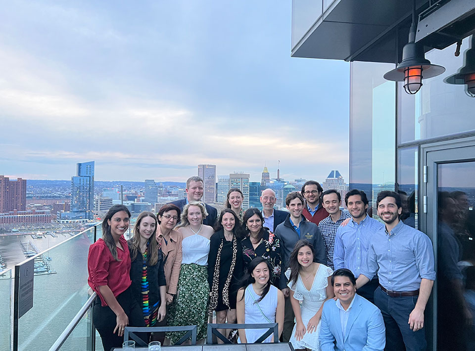 a group of fellows posing outside at a rooftop restaurant