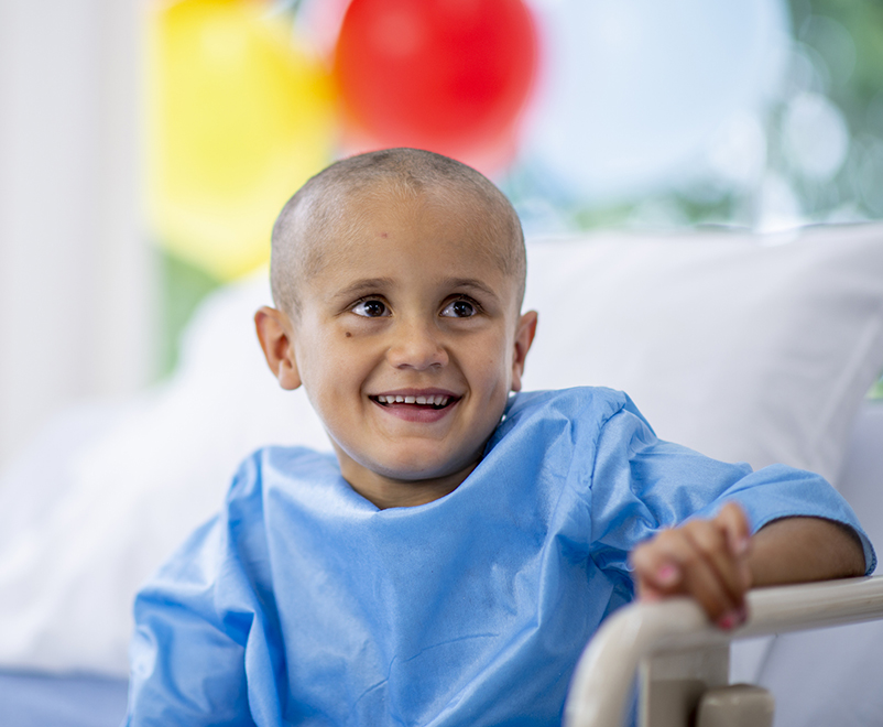 pediatric anesthesiology - boy in hospital gown smiling away from camera