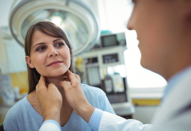 doctor examining patient's neck - heart and vascular institute
