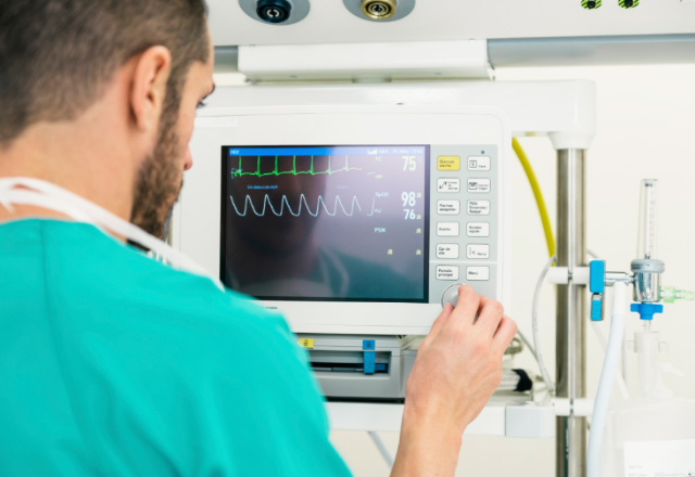 doctor observing ekg monitor - heart and vascular institute