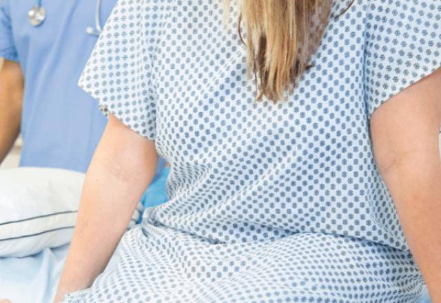 heart and vascular institute - woman wearing hospital gown sitting on hospital bed