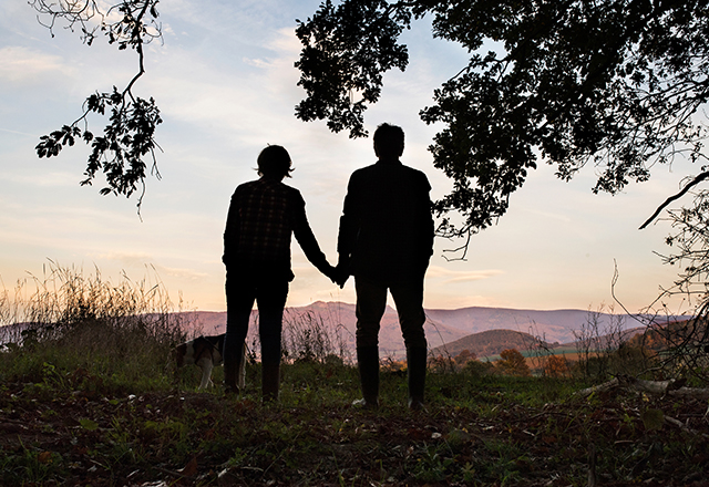 diabetic foot and wound clinic - silhouette of man with wife walking dog in the woods