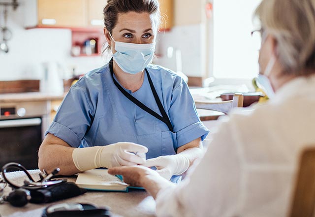 Nurse sitting at table with patient