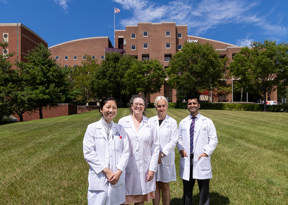 Hospital medicine fellowship leaders standing outside on Bayview campus wearing white coats.