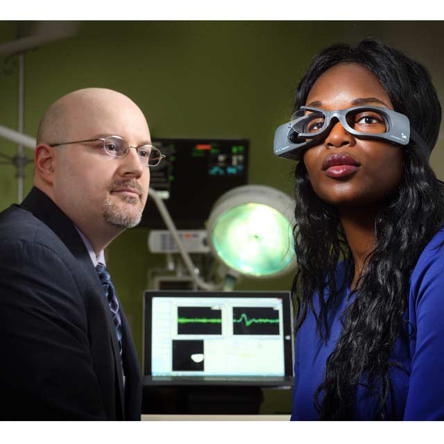 David Newman-Toker looking at woman wearing goggles