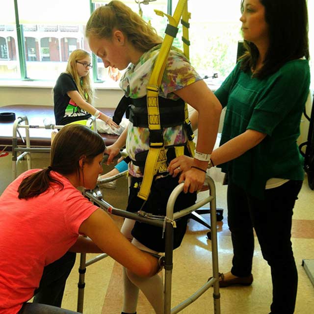 Girl receiving assistance with her walker