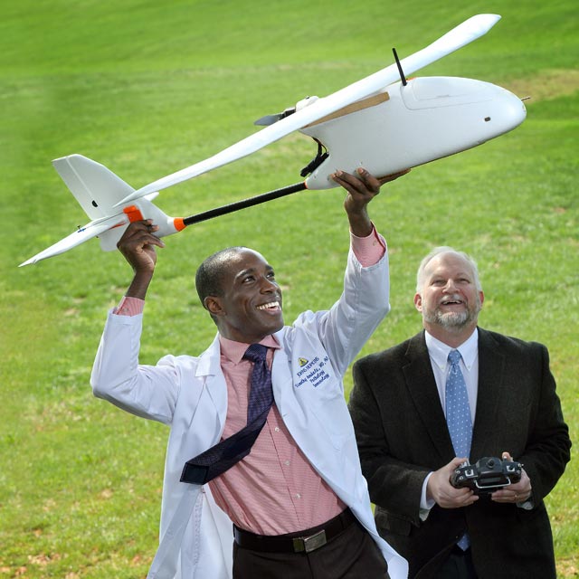 Pathologist Timothy Amukele, left, holds an unmanned aerial vehicle next to Robert Chalmers.