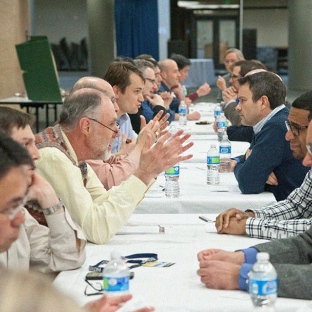 Scientists sit across from each other in a speed-dating scenario.