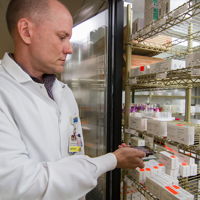 Photos shows immunology lab supervisor Matthew Morrow checking inventory using the JumpStock app.