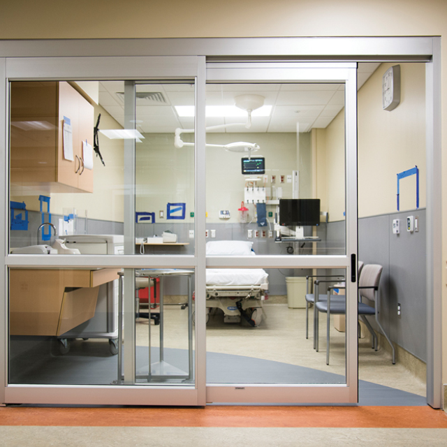Photo shows a new Sibley Memorial Hospital patient room with glass doors and privacy curtains.