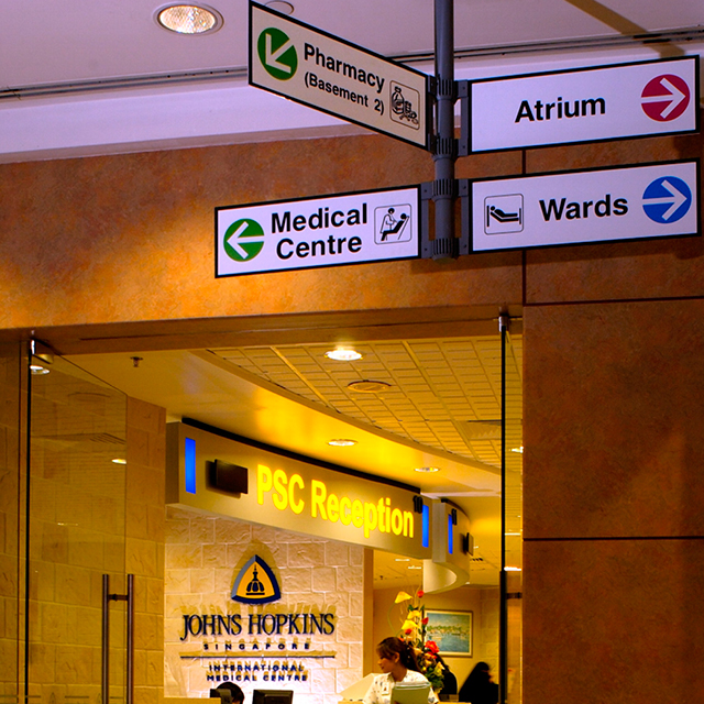 A photo shows the front desk of Johns Hopkins Singapore.
