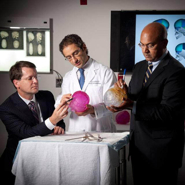 Craniofacial surgeons examine a 3-D model