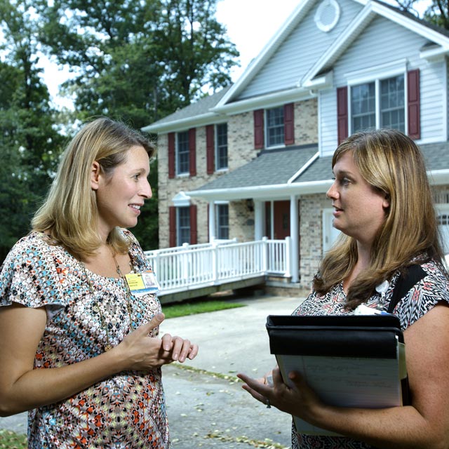 Quincy Samus, left, reviews a patient’s care plan with memory care coordinator Kelly Marshall outside a client’s home.