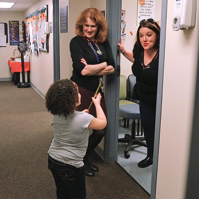 A photo shows a child interacting with people at the Center for Addiction and Pregnancy.
